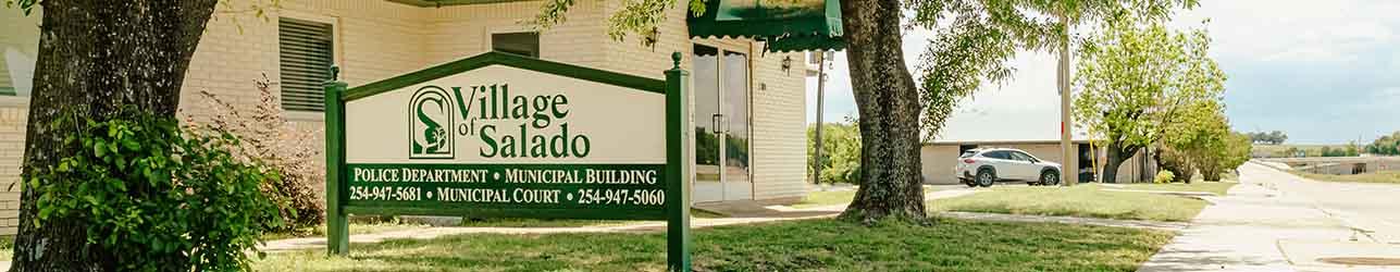 Building sign along a path with trees on the sides 