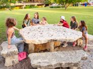Kids sit around a picnic table at Serena Park