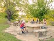 Pictures of children talk around a picnic table at Serena Park 