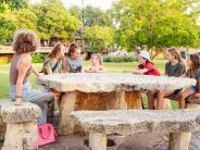 Pictures of children talk around a picnic table at Sirena Park