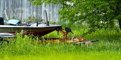 Code violation of a yard with high weeds and rusty boat with scraps